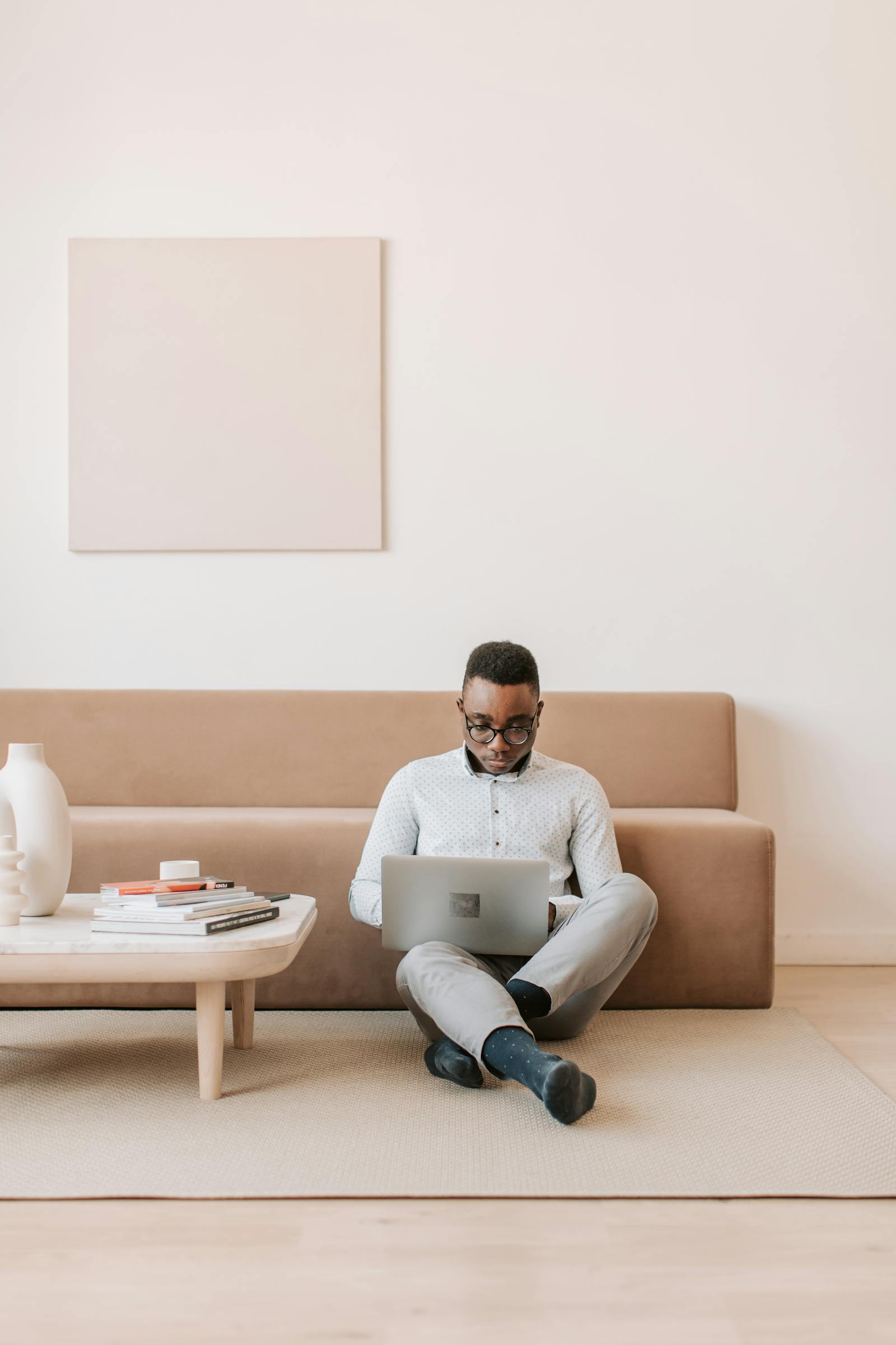 Professional working on a laptop in a calm, light-filled apartment with neutral palette