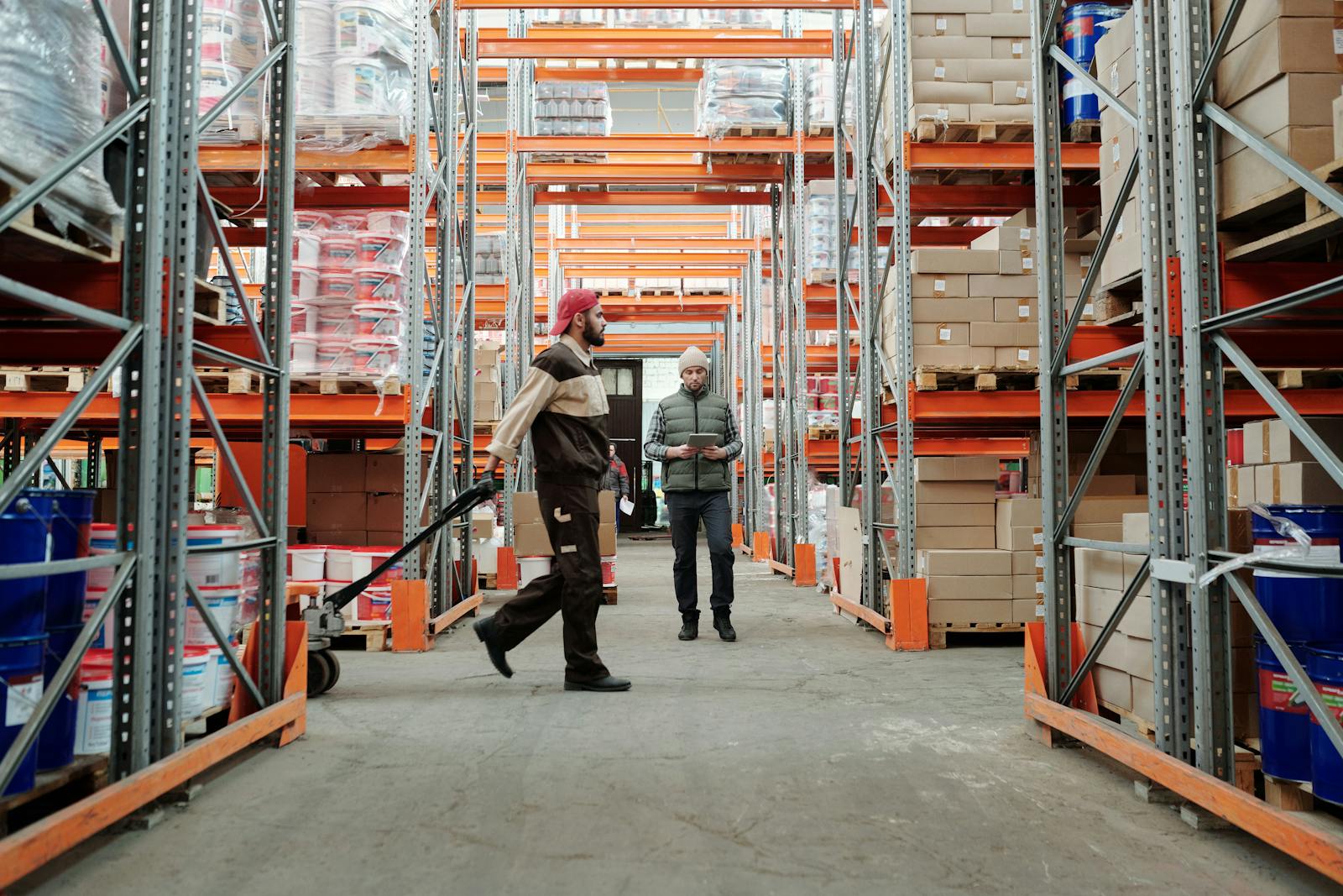 Two warehouse workers managing inventory in a fulfillment aisle